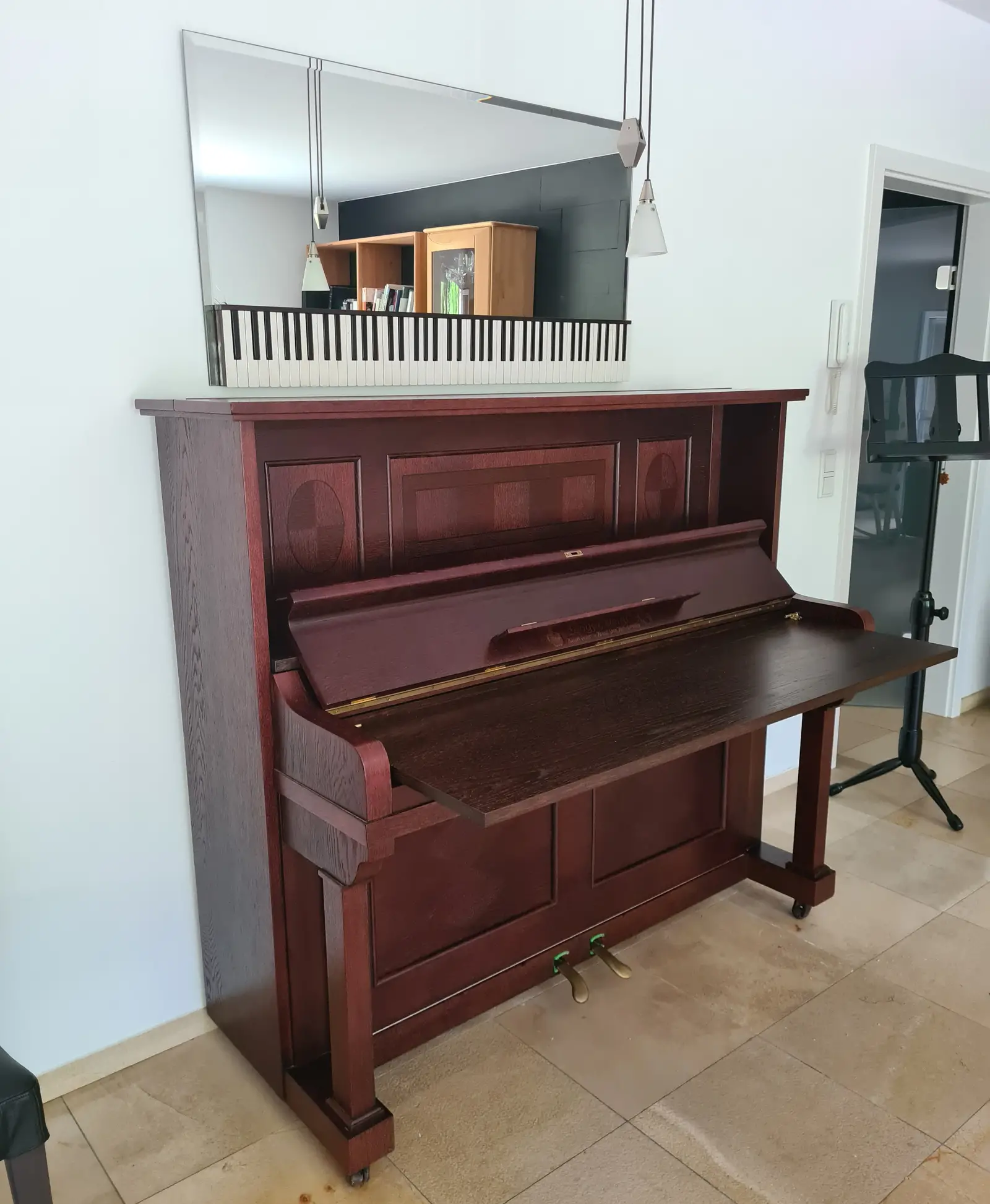 Klavier in dunklem Holz,
 Spiegel darüber mit Tasten des Musikinstrument